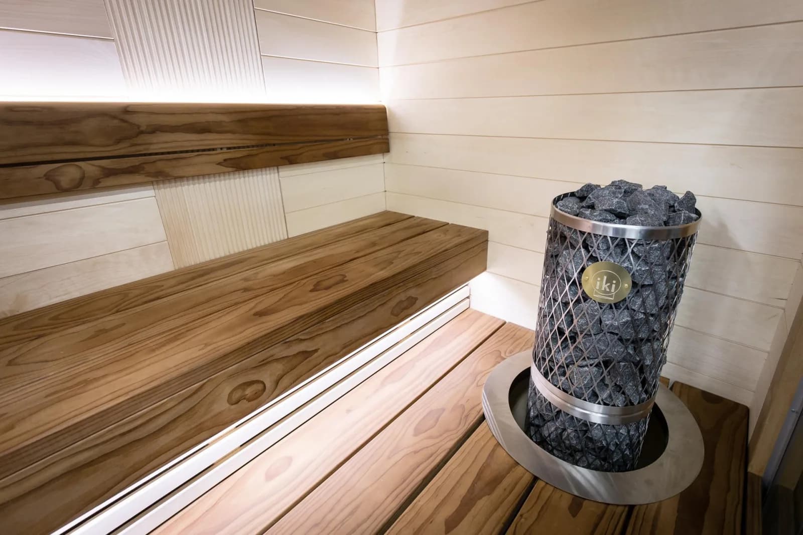 IKI electric sauna heater installed in a wood-paneled sauna