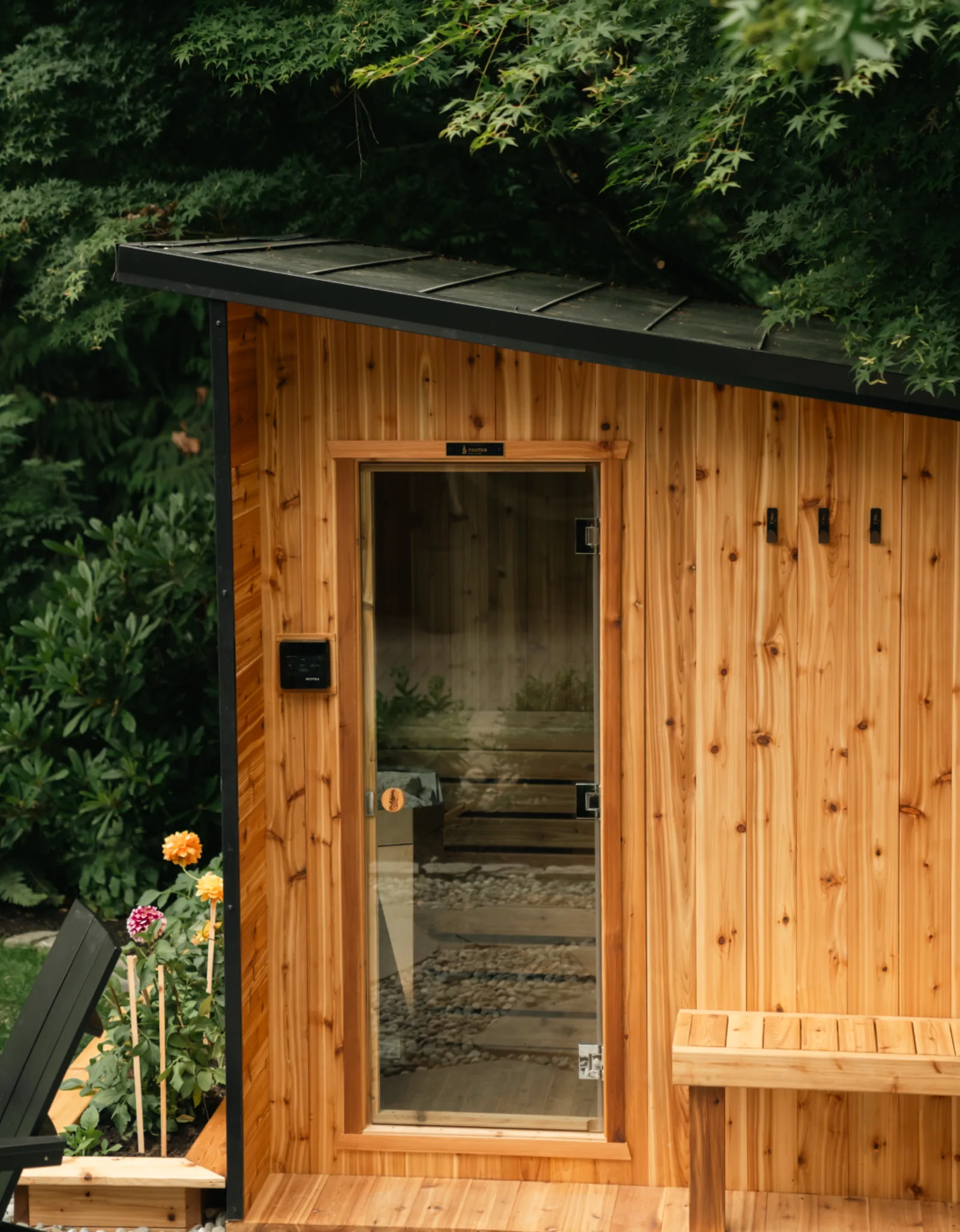 Nootka Cube Sauna exterior, angled view showing the cedar cabin and glass door