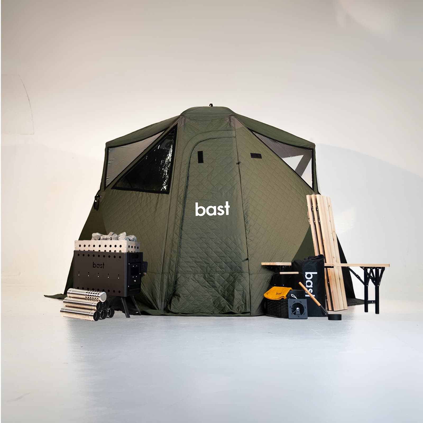 Björk Premium (dark green) sauna tent with the full bast setup: wood stove, firewood, folding bench, bucket and ladle