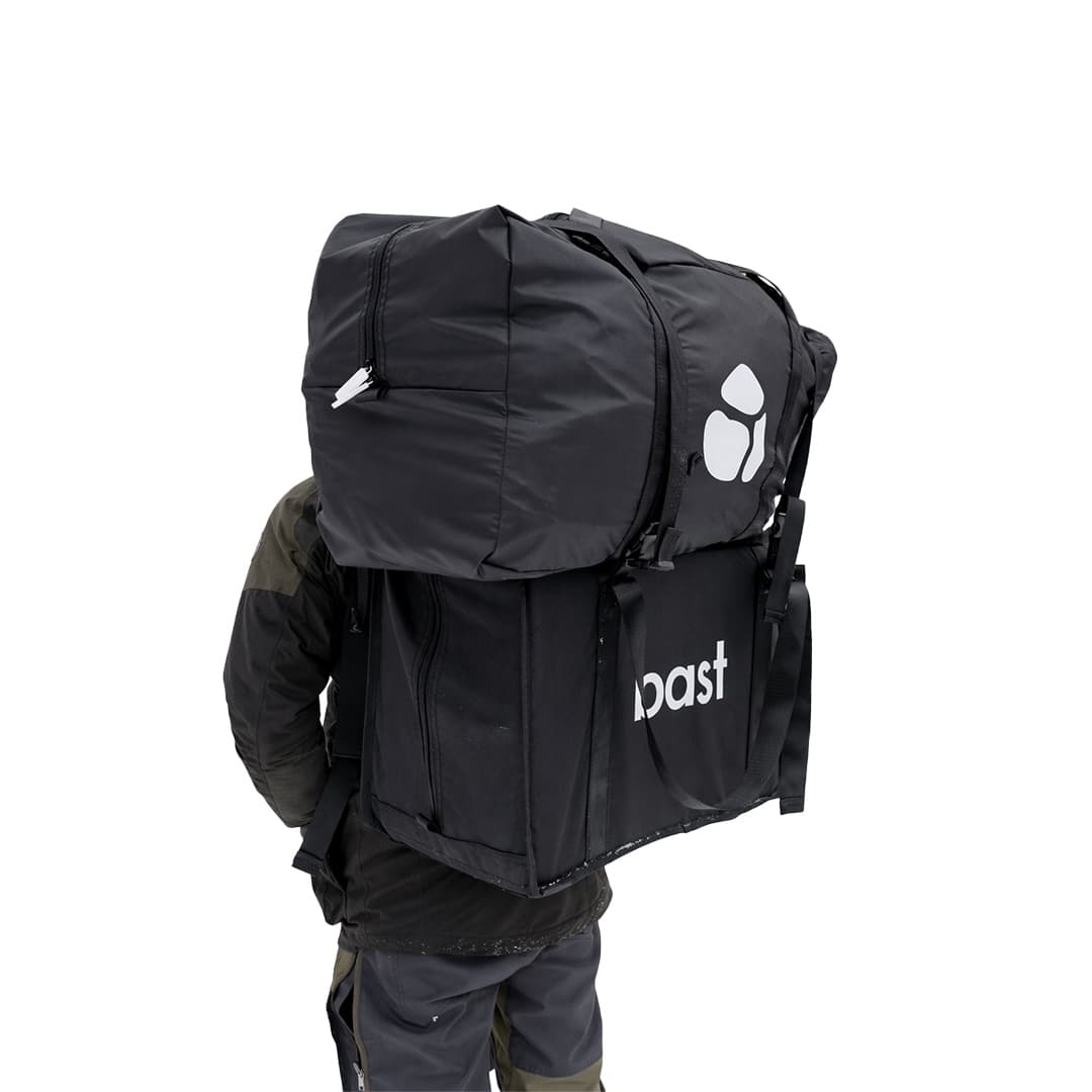 The Näver packed down into a single carry bag with the bast wordmark, worn as a backpack